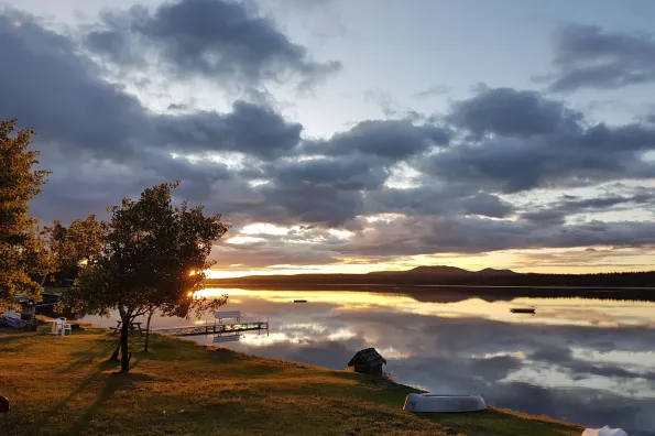 View of a beach on a lake at sunset
