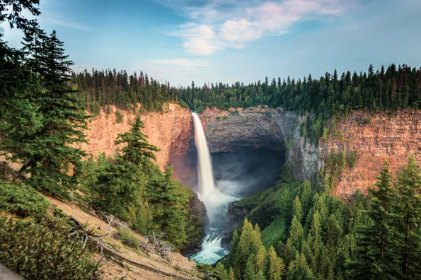 A waterfall going into blue water in the forest