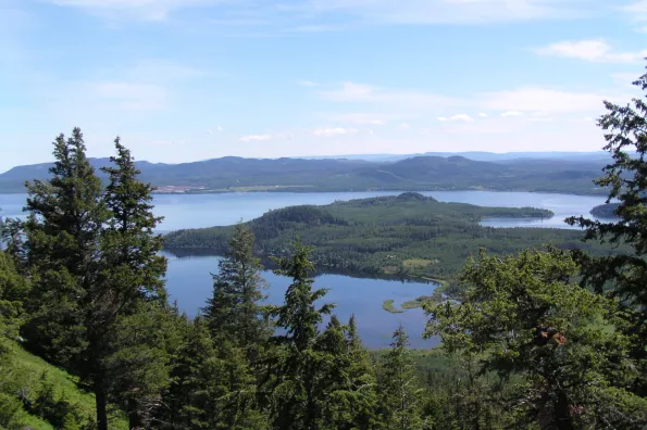 A mountaintop view overlooking a blue lake. 