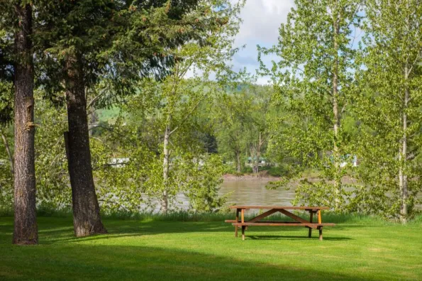 A picnic bench on a grassy area overlooking a river
